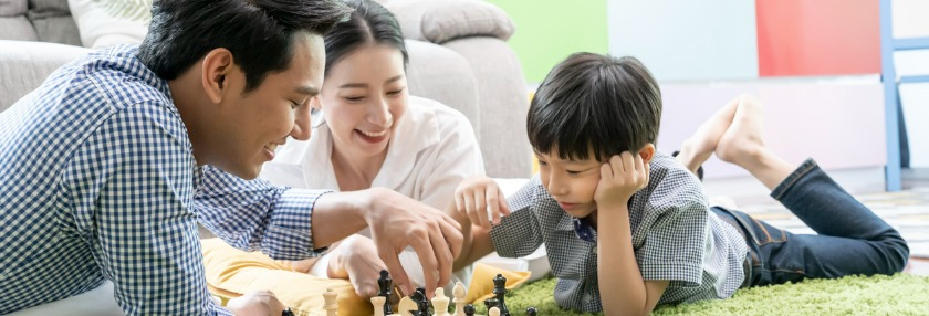 Parents playing a board game with their son
