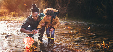 Father and son fishing with fishing net in river