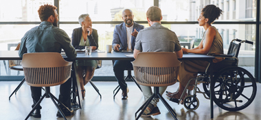 Colleagues in a meeting discussing around a table