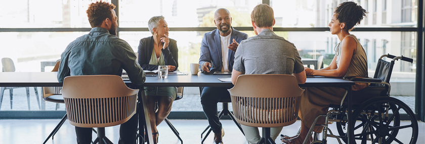 Colleagues in a meeting discussing around a table