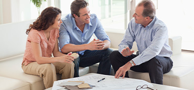 Couple sitting on sofa talking to financial advisor