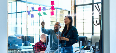 Chinese woman and male colleague in office with adhesive notes