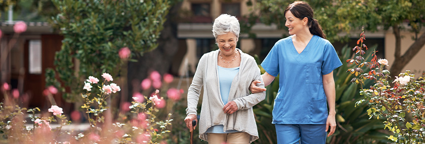 Carer assisting elderly lady in the garden
