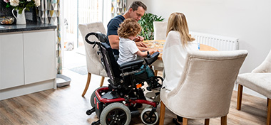 Boy in wheelchair doing jigsaw with parents