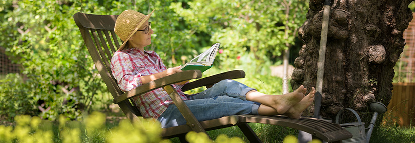 Older lady relaxing sat in the garden