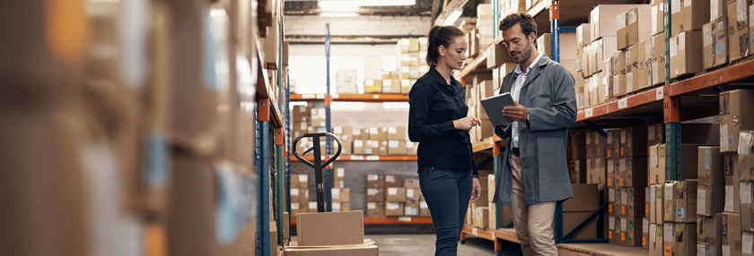 Man and woman using a digital tablet while working together in a warehouse