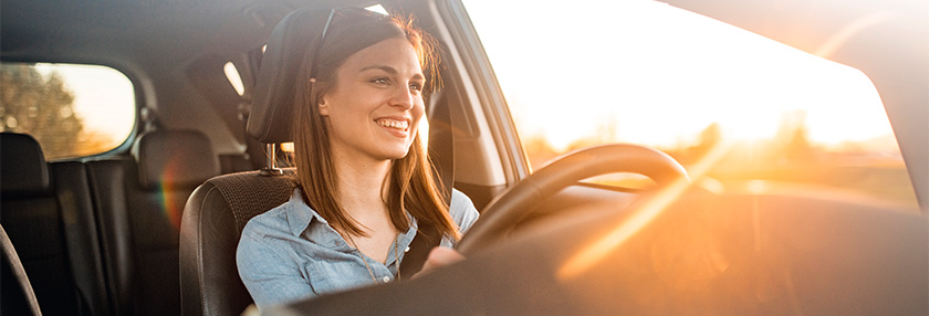 Young woman driving car on a sunny day