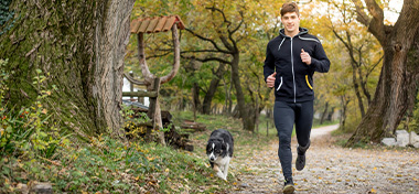 Man running outside with his dog