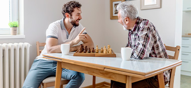 Son and Senior Father Playing Chess Together