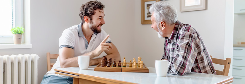 Son and Senior Father Playing Chess Together