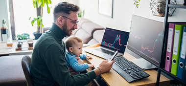 Man looking at trading app on his smart phone from his home office
