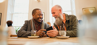 Two men chatting over coffee together