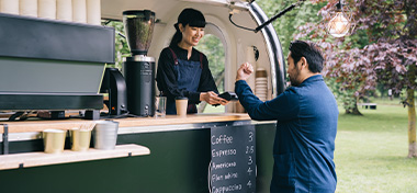 Women serving coffee to a male customer