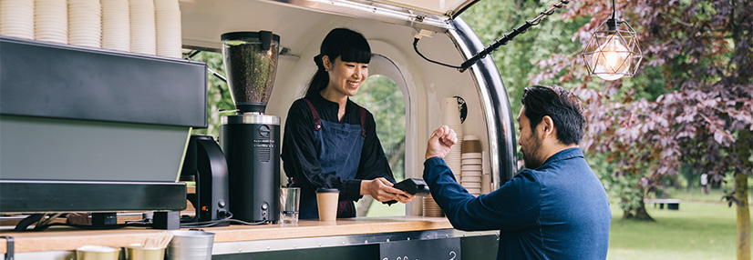 Women serving coffee to a male customer