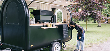 Barista writing the menu on her coffee trailer 