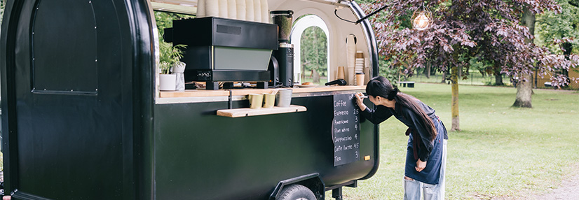 Barista writing the menu on her coffee trailer 