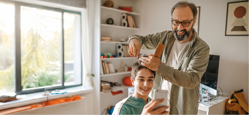 Father cutting son's hair