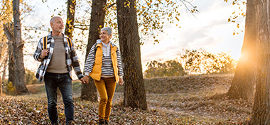 Couple walking together in wooded area 
