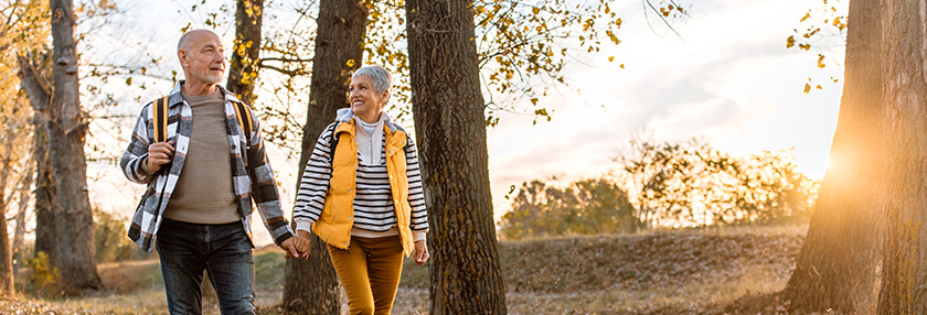 Couple walking together in wooded area 