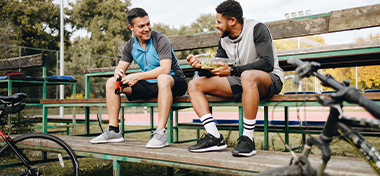 Two males chatting on a bench