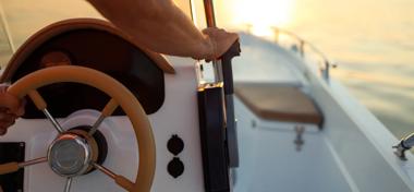  Boat life - stock photo Close-up shot of a man's hand on a speedboat's steering wheel at sunset 