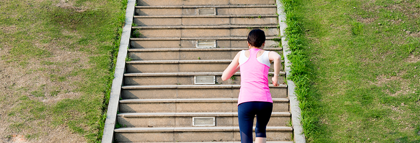Young woman running at stone stairs 