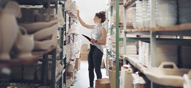 Businesswoman with digital tablet checking the stock in ceramic factory warehouse