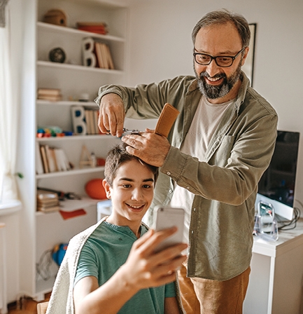 father cutting sons hair
